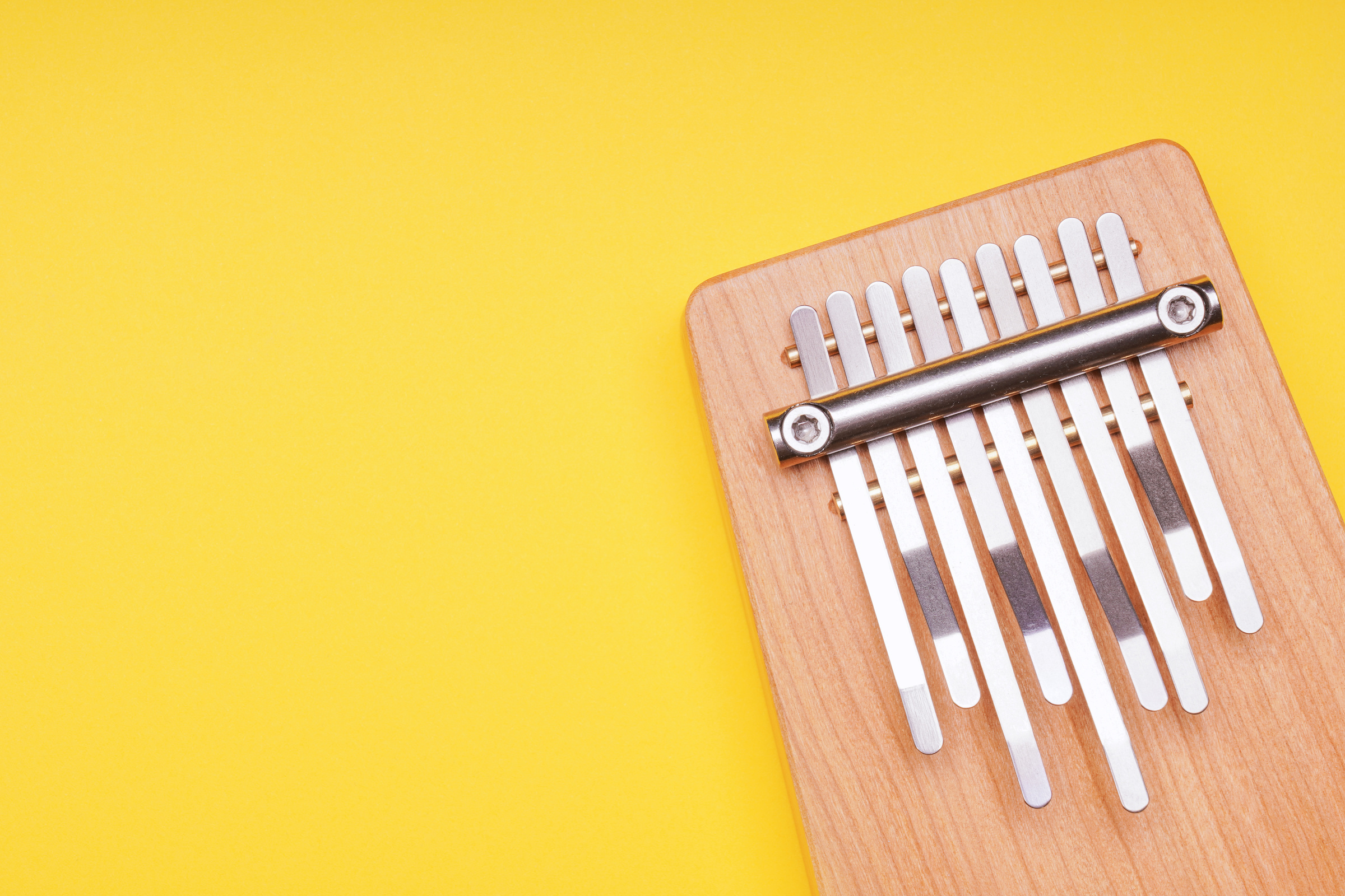 Kalimba Music Instrument on Yellow Background with Copy Space